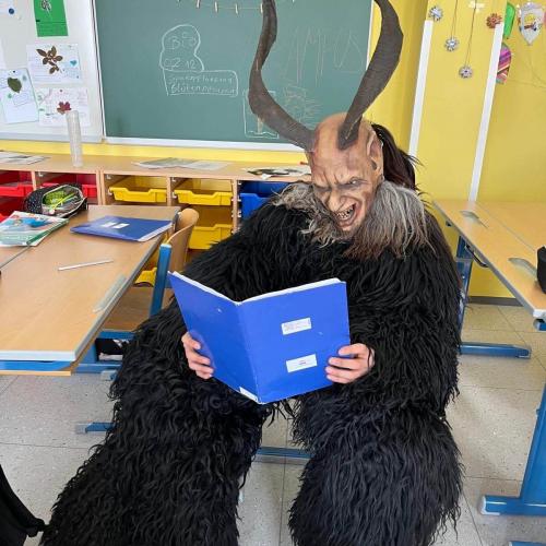 Krampus liest eine Geschichte aus dem Buch